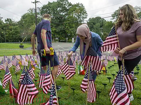 New Jersey's Cedar Grove High School students install a flag for each of the 2,977 people killed in the 9/11 terrorist attacks two decades ago. Educators use the memorial, called Cedar Grove Waves, to teach the magnitude of the attacks.
