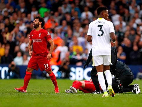 Liverpool's Mohamed Salah reacts as Harvey Elliott receives medical attention after sustaining an injury.