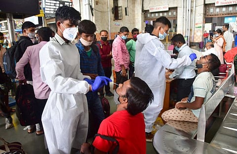 BMC health workers collect swab samples from passengers for COVID-19 testing at CSMT Railway Station in Mumbai.