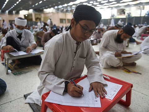 Students of the Jamia Binoria Al Alamia (Binoria University International) seminary sit for an exam during their first semester in Karachi on September 11, 2021. )