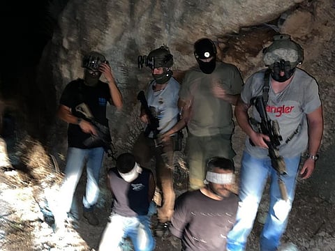 Israeli security forces stand next to two Palestinian fugitives Zakaria Zubeidi, left, and Mohammed Ardah after being recaptured in the Arab town of Umm Al Ghanam, northern Israel.