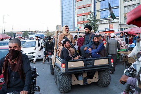 Taliban soldiers sit on the back of a truck in a street in Kabul on September 16, 2021.