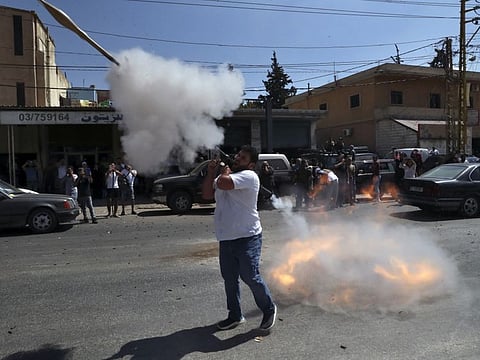 A Hezbollah supporter fires a rocket-propelled grenade in the air to celebrate the arrival of Iranian fuel tankers to Lebanon, in the eastern town of Baalbek, on September 16, 2021.