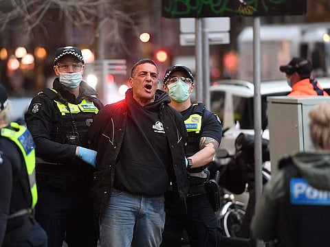 Police arrest a demonstrator in Melbourne on September 21, 2021.