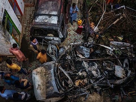 Relatives and neighbours of the Ahmadi family gather around the incinerated husk of a vehicle that was hit by a US drone strike, killing 10 people, in Kabul, Afghanistan, August 29, 2021.