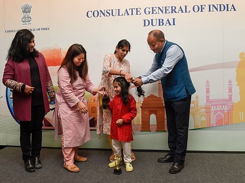 Consul Jitender Singh Negi cutting hair of three-year-old Taksh Jain who donated his hair along with the other boys to cancer patient Nadiera Senali Veedu, at the Indian Consulate in Dubai.