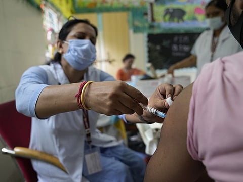 A health worker administers a vaccine at a government-run school in New Delhi on September 21, 2021.