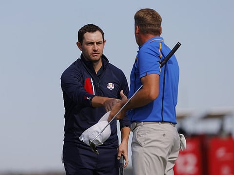 Team USA's Patrick Cantlay shakes hands with Team Europe's Ian Poulter on the 15th green after Team USA win the match during the Foursomes.