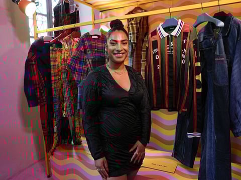 Designer Priya Ahluwalia poses for a portrait in front of her creations for Gucci, inside the the Gucci unveiled new on-line concept store, called Gucci Vault, featuring refurbished vintage Gucci pieces and collections by young designers. The project was presented in Dazio del Ponente in Milan's Parco Sempione, where a sampling of the items on sale were displayed during the Milan Fashion Week, in Milan, Italy, Saturday, Sept. 25, 2021.