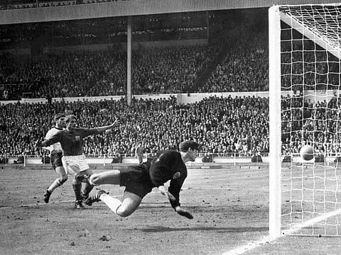 England's Roger Hunt raises his arms as Geoff Hurst scores England's third goal against West Germany in the 1966 World Cup final
