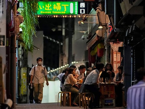 People gather at bars that are open and serving alcohol on an ally filled with bars and restaurants despite Tokyo government has requested businesses not to serve alcohol under the state of emergency on September 22, 2021.