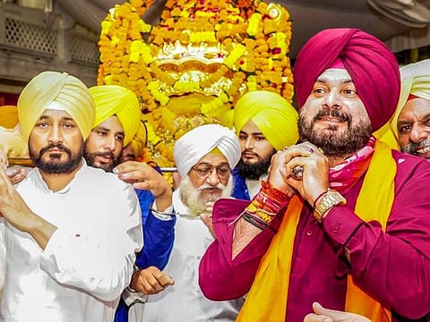 Punjab Chief Minister Charanjit Singh Channi along with PPCC President Navjot Singh Sidhu perform the voluntary service of carrying the palanquin of Guru Granth Sahib during their visit to pay obeisance at Golden Temple in Amritsar, on September 22, 2021.