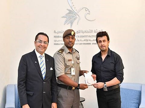 Rizwan Sajan, Founder and Chairman of Danube Group with Bollywood singer Sonu Nigam as he receives his Golden Visa from a government official in the UAE.