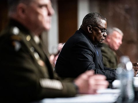 Defense Secretary Lloyd Austin listens as Gen. Mark A. Milley, chairman of the Joint Chiefs of Staff, left, testifies during a Senate Armed Services Committee hearing Tuesday on the end of military operations in Afghanistan. On the far right is Gen. Kenneth "Frank" McKenzie, chief of U.S. Central Command.