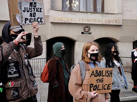 Demonstrators hold placards as they await the sentencing of British police officer Wayne Couzens for the murder of Sarah Everard, outside the Old Bailey court in London on September 29, 2021.