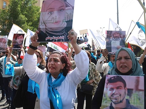 Protesters hold posters of protesters who have been killed in anti-government demonstrations during anti-Government protest in Tahrir Square, Baghdad, Iraq, Friday, October 1, 2021.