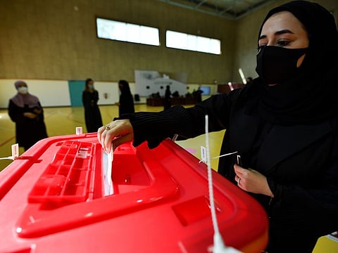 A Qatari woman casts her vote in the Gulf Arab state's first legislative elections for two-thirds of the advisory Shura Council, in Doha, on October 2, 2021.