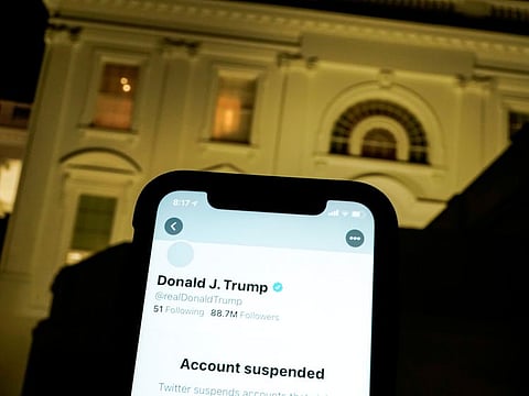 A photo illustration shows the suspended Twitter account of US President Donald Trump on a smartphone and the White House in Washington, on January 8, 2021.