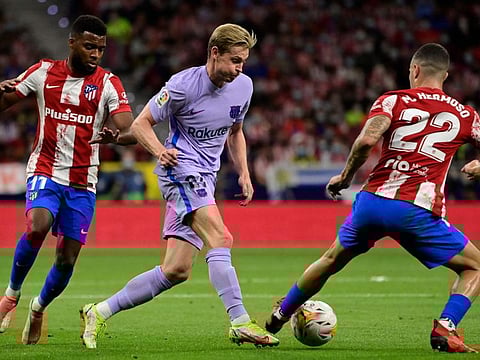 Atletico Madrid's French midfielder Thomas Lemar (left), Barcelona's Dutch midfielder Frenkie De Jong (centre) and Atletico Madrid's Spanish defender Mario Hermoso fight for the ball during the Spanish League football match at the Wanda Metropolitano stadium in Madrid.