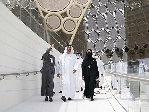 His Highness Sheikh Mohamed bin Zayed Al Nahyan, Crown Prince of Abu Dhabi and Deputy Supreme Commander of the UAE Armed Forces (C); Reem Al Hashimi, Minister of State for International Cooperation and Director-General of Expo 2020 Dubai (R); and Noura Al Kaabi, Minister of Culture and Youth, Commissioner-General of the UAE Pavilion at Expo 2020 Dubai (L), arrive at the UAE Pavilion during a visit to Expo 2020 Dubai on Sunday