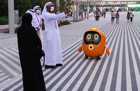 Visitors take pictures of a robot outside the Dutch pavilion at the Expo 2020 Dubai