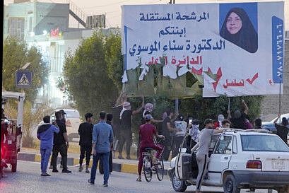 Demonstrators tearing electoral posters for the upcoming parliamentary elections during anti-Government protests in Najaf, Iraq, on October 1, 2021.