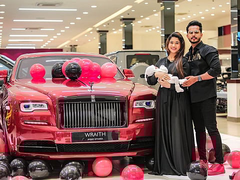 Amjad Sithara and wife Marjana pose in front of the luxury car with their baby Ayra Malika