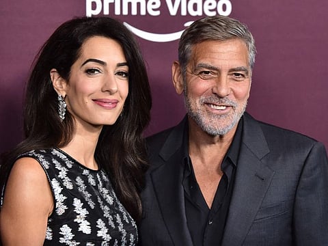 Lebanese-British barrister Amal Clooney and husband George Clooney arrive for "The Tender Bar" premiere at the Directors Guild of America Theatre in Los Angeles, California, on October 3, 2021.