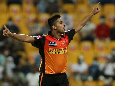 Umran Malik of the Sunrisers Hyderabad celebrates after claiming the wicket of Royal Challengers Bangalore’s K.S. Bharat in the IPL 2021 game in Abu Dhabi on October 6, 2021.
