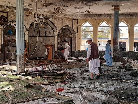 Afghans inspect the mosque following a bombing in Kunduz province on October 8, 2021.
