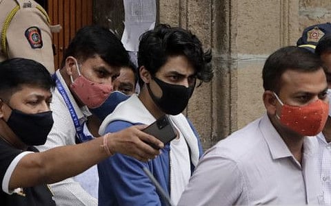 Bollywood actor Shah Rukh Khan's son Aryan Khan is escorted by law enforcement officials from the Narcotics Control Bureau office and taken for a medical check up, in Mumbai, India, Friday, Oct. 08, 2021.