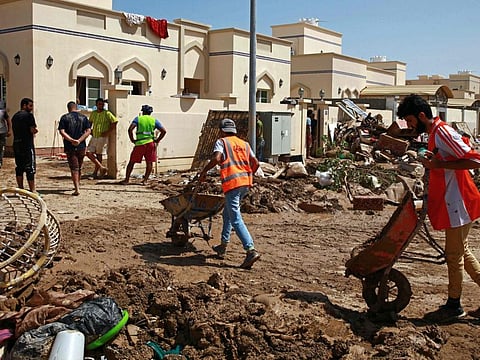 Omani volunteers clean homes affected by the Cyclone Shaheen in Al Khaburah city of Oman's Al Batinah region on October 8, 2021.