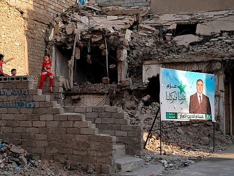 Campaign posters for parliamentary elections are displayed near destroyed buildings from fighting between Iraqi forces and Daesh in Mosul October 3, 2021.