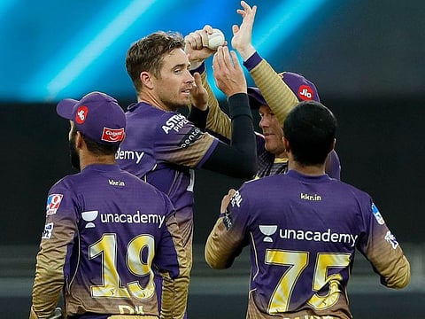 Kolkata Knight Riders’ Tim Southee celebrates after claiming the wicket of Wriddhiman Saha of Sunrisers Hyderabad, with captain Eoin Morgan and Dinesh Karthik during the IPL match at the Dubai International Stadium on October 3, 2021.