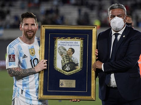 The president of the Argentine Football Association Claudio Tapia (right) awards Argentina's Lionel Messi with the top international goal scorer in South American history, at the end of the South American qualification football match against Uruguay for the FIFA World Cup Qatar 2022 at the Monumental stadium in Buenos Aires.