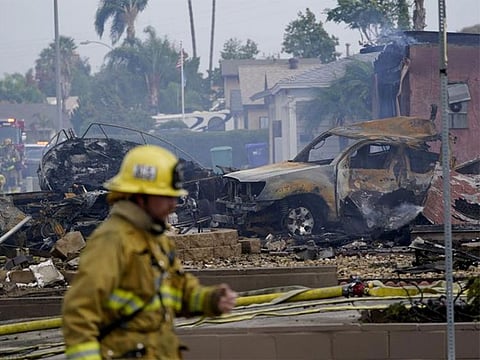 Fire crews work the scene of a small plane crash on October 11, 2021, in Santee, California