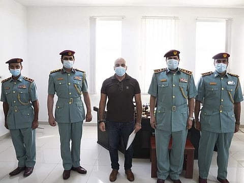 Mohamed Magdy Hakami (centre) being honoured by Ajman Police for saving life of drowning boy