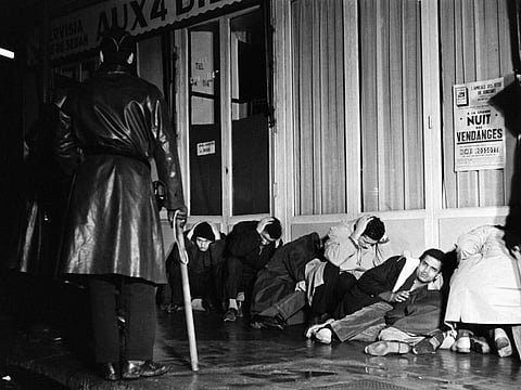 In this file photo taken on October 17, 1961 Algerian demonstrators arrested in Puteaux, west of Paris, during the peaceful demonstration wait with their hands above their heads to be questionned under police surveillance, during the Algerian war.