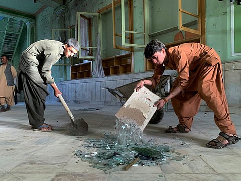 People inspect the inside of a mosque following suicide bombing at a Shiite mosque in Kandahar.