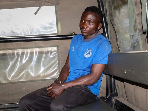 Murder suspect Masten Wanjala sits in the back of a police truck after being taken by police to a scene to identify the location of alleged victim remains, on the outskirts of Nairobi on July 14, 2021. Police in Kenya said Friday the man who police say confessed to killing a dozen children and escaped from detention this week has been killed by a mob.
