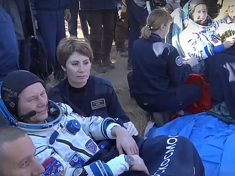 This handout video grab taken and released on October 17, 2021 by the Russian Space Agency Roscosmos shows crew members, Russian actress Yulia Peresild (R) and Russian cosmonaut Oleg Novitsky (L), reacting after the landing of the Russian Soyuz MS-18 space capsule in a remote area southeast of Zhezkazgan in the Karaganda region of Kazakhstan, on October 17, 2021. AFP