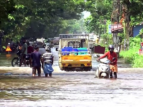 Vehicles move through a waterlogged road following incessant rainfall in Changanassery Road, Kerala on Monday.