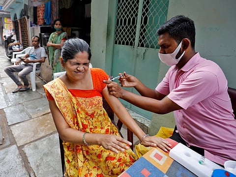 A woman receives a dose of vaccine in an alley at a slum area in Ahmedabad. Monday’s 13,596 new cases were India’s lowest rise in 230 days, taking its tally of infections past 34 million. Deaths rose by 166 to stand at 452,290.