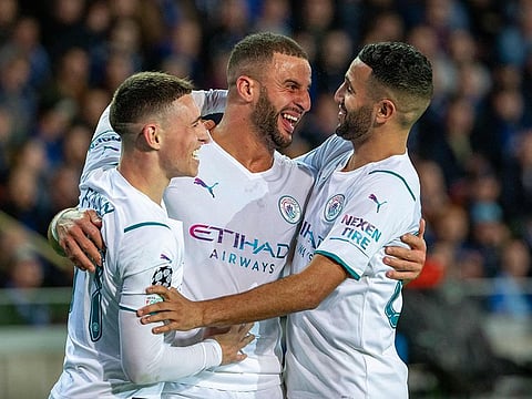 Kyle Walker (C) is congratulated by team mates Phil Foden (L) and Riyad Mahrez (R) after scoring.