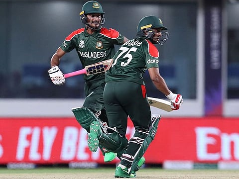 Bangladesh's Shakib Al Hasan (right) and Mohammad Naim take a run during the ICC Men's Twenty20 World Cup cricket match against Oman in Muscat on October 19, 2021.