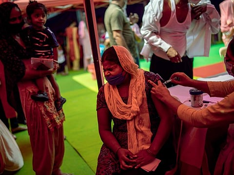 A health worker inoculates a woman during a vaccination drive against COVID-19 in New Delhi in a file photo.