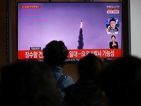 People watch a TV broadcasting file footage of a news report on North Korea firing a ballistic missile off its east coast, in Seoul, South Korea, October 19, 2021.