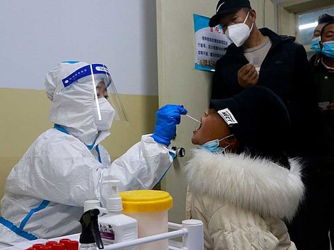 This photo taken on October 20, 2021 shows a resident undergoing a nucleic acid test for the COVID-19 coronavirus in Zhangye in China's northwestern Gansu province.