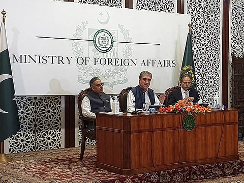 Pakistani Foreign Minister Shah Mahmood Qureshi (centre) along with Foreign Secretary Sohail Mahmood and Foreign Office spokesperson Asim Iftikhar, speaks during a news conference in Islamabad on October 21, 2021.