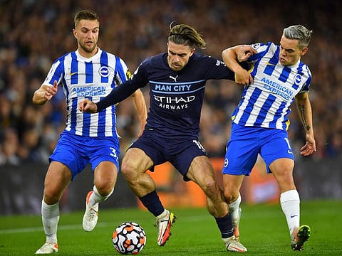 Manchester City's Jack Grealish in action with Brighton & Hove Albion's Leandro Trossard and Joel Veltman.